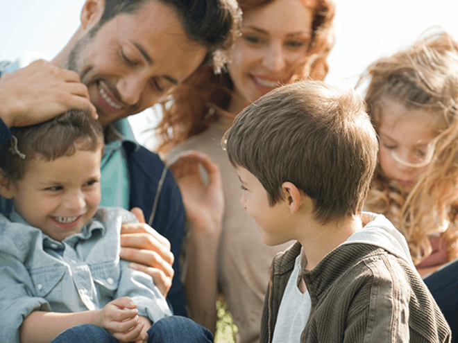 Una linda familia disfrutando juntos en el césped con un niño