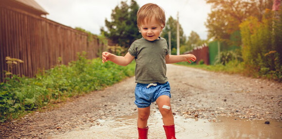 Un niño caminando por un charco de agua.