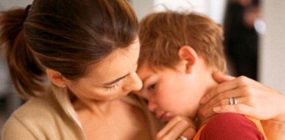 Mamá consolando a su hijo que está triste.