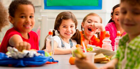 Niños comiendo en la mesa los probióticos saludables.