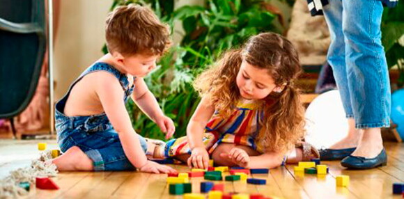 Dos niños jugando con cubos de madera