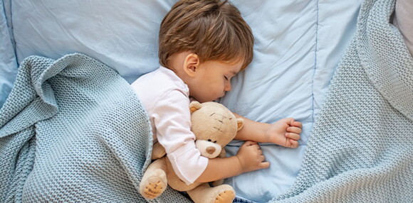 Un niño durmiendo y apoyando la curva de crecimiento y desarrollo