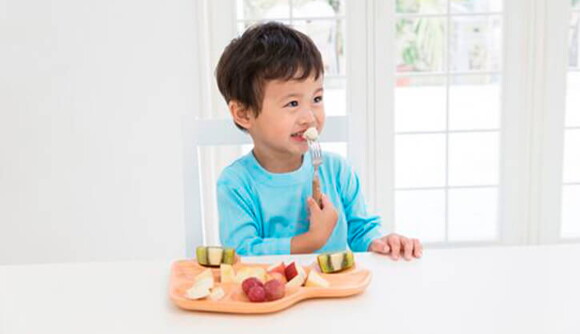 Niño contento consumiendo probióticos saludables.